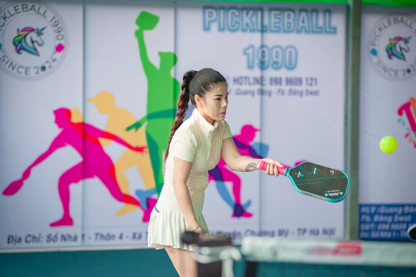 Player holding a pickleball paddle, showing grip and handle length