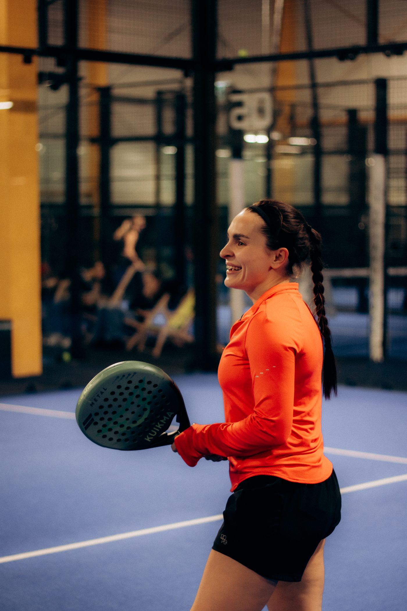 Padel being played on an indoor court with glass walls