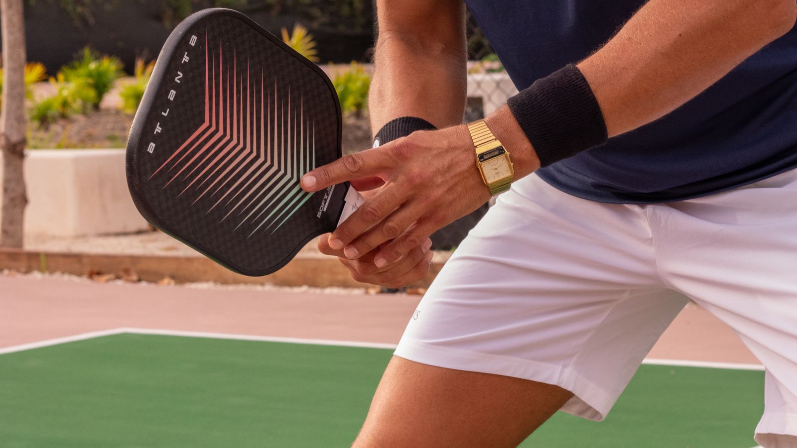 Player holding a carbon fiber pickleball paddle in ready position on an outdoor court