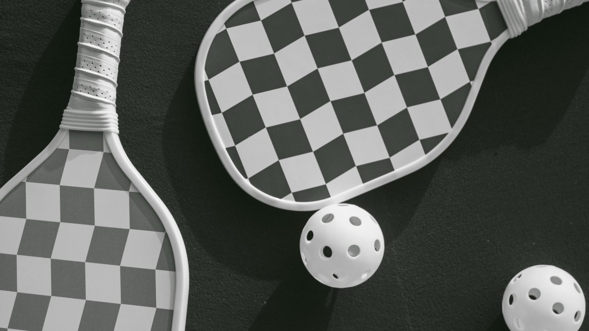 Pickleball paddles and balls viewed from above on a dark background