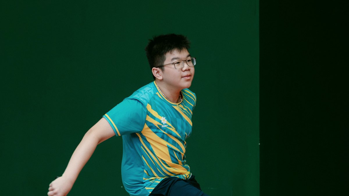 Young player following through on a shot on an indoor pickleball court
