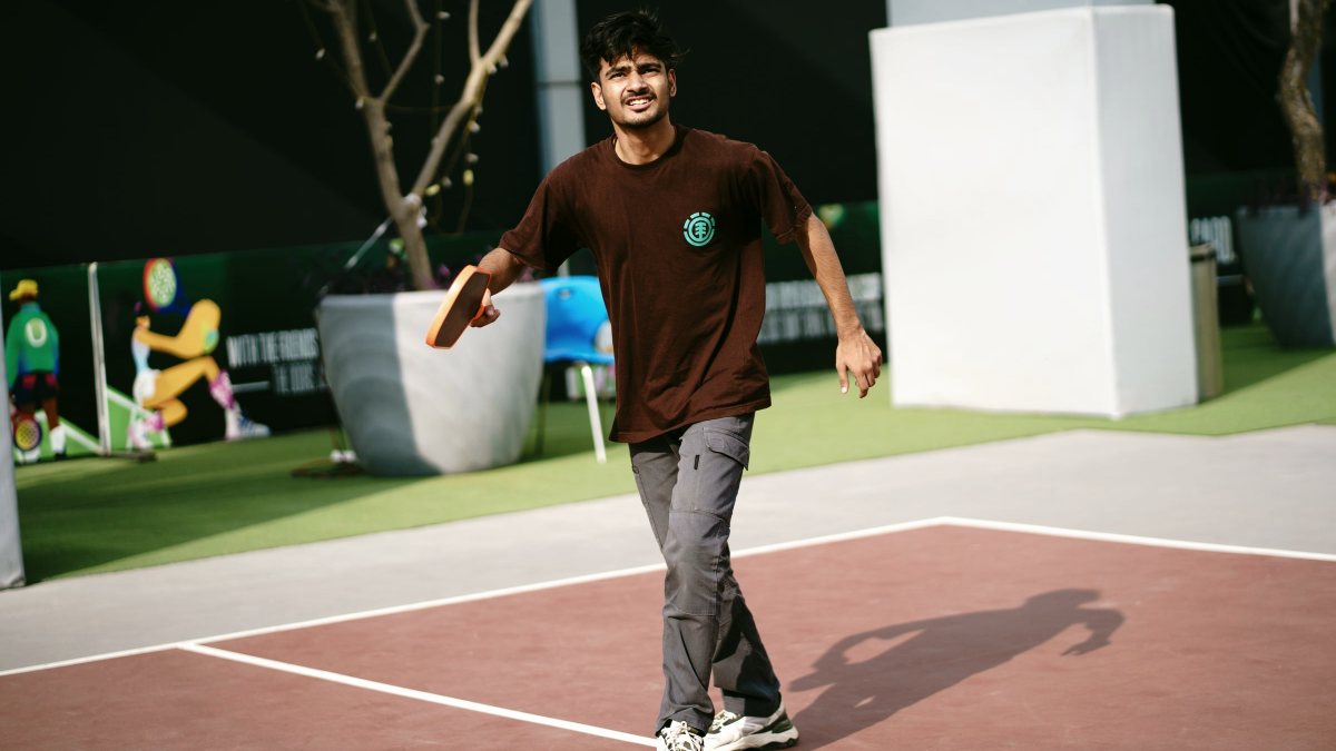 Player mid-rally on an outdoor pickleball court